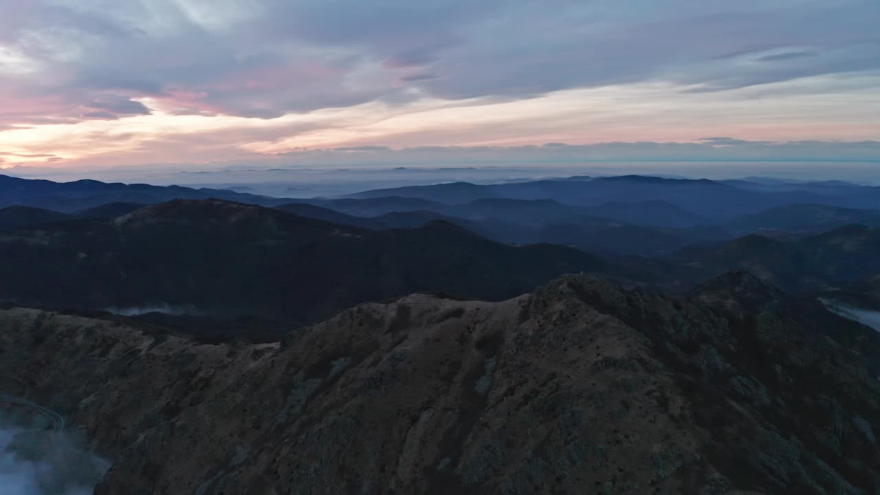 黄昏时分，山峰从云海中浮现，天空宁静，鸟瞰视频素材