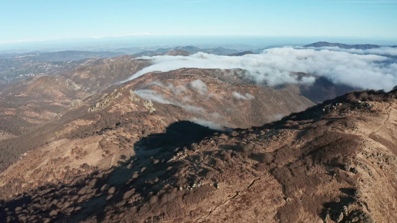 山景与云翻滚的山峰，投下阴影，晴朗的天空，空中透视视频素材