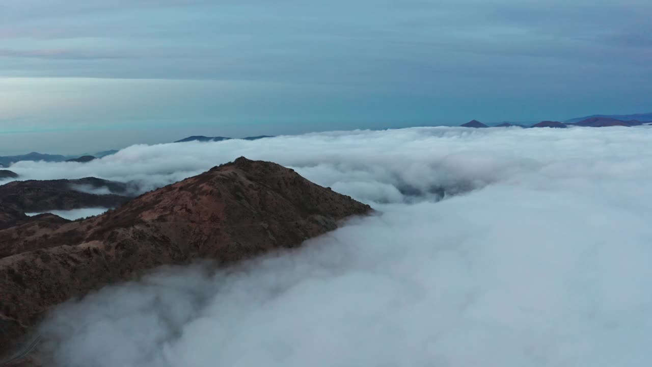 黄昏时分，雄伟的山峰从云海中浮现，鸟瞰视频素材