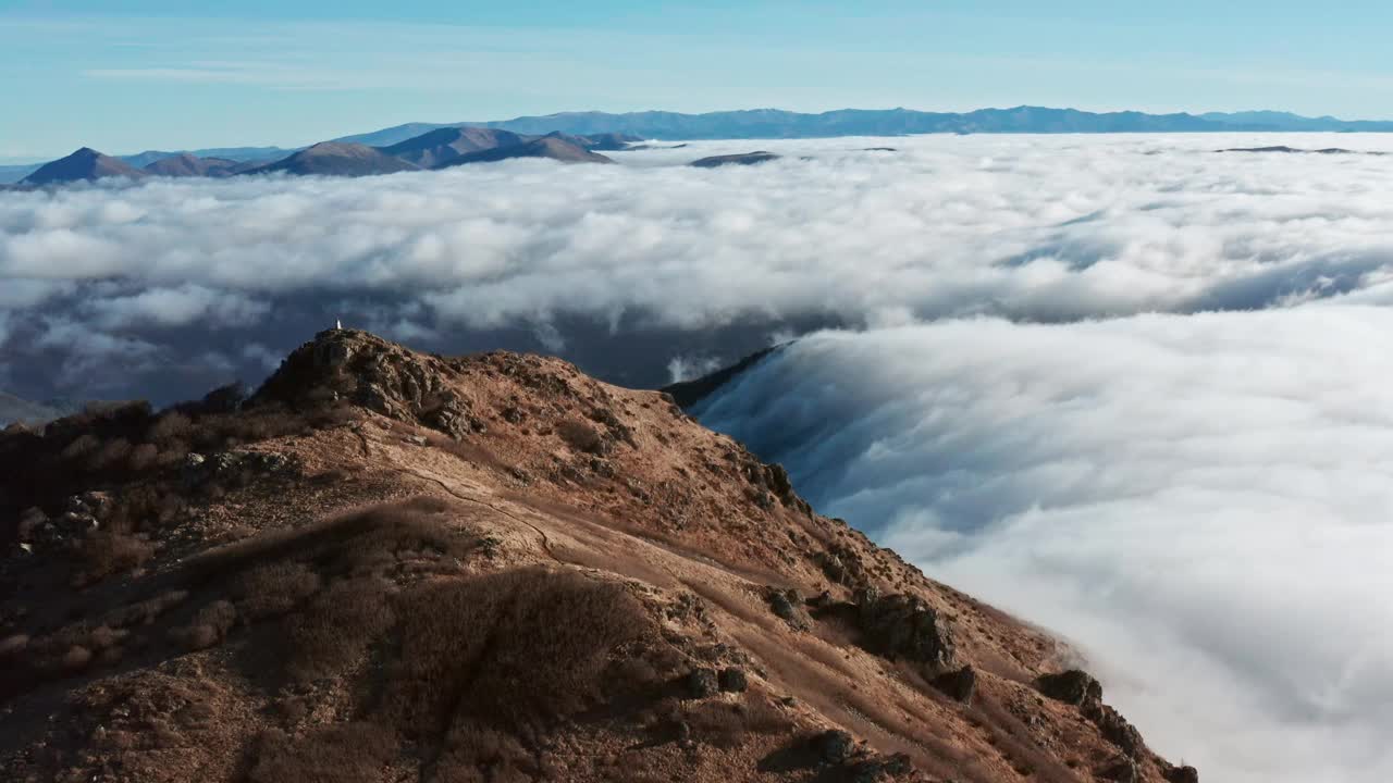 青山高耸云海，碧蓝晴空下，远处孤独的身影视频素材