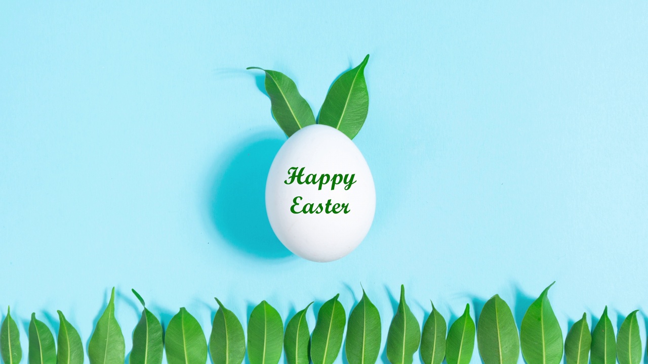 复活节快乐。用绿叶装饰的白色彩蛋，象征着复活节兔子。视频下载