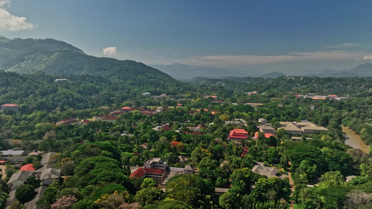 Peradeniya Sri Lanka Aerial v9无人机飞越位于Mahaweli河岸边的大学校园，捕捉郁郁葱葱的绿色植物和山坡景观，使用Mavic 3 Cine拍摄，2023年4月视频素材