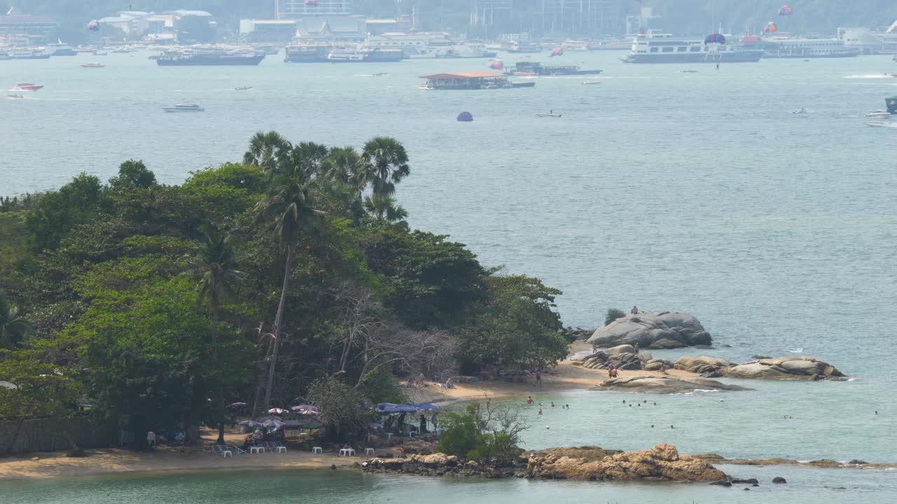 美丽的泰国海滩，游客和外籍人士在绿松石色的海水中享受日光浴和游泳。视频素材