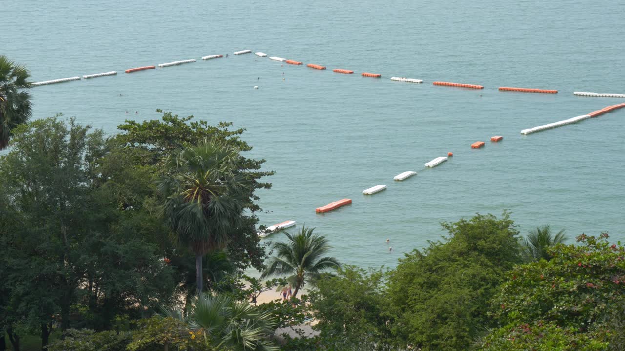 美丽的泰国海滩，游客和外籍人士在绿松石色的海水中享受日光浴和游泳。视频素材