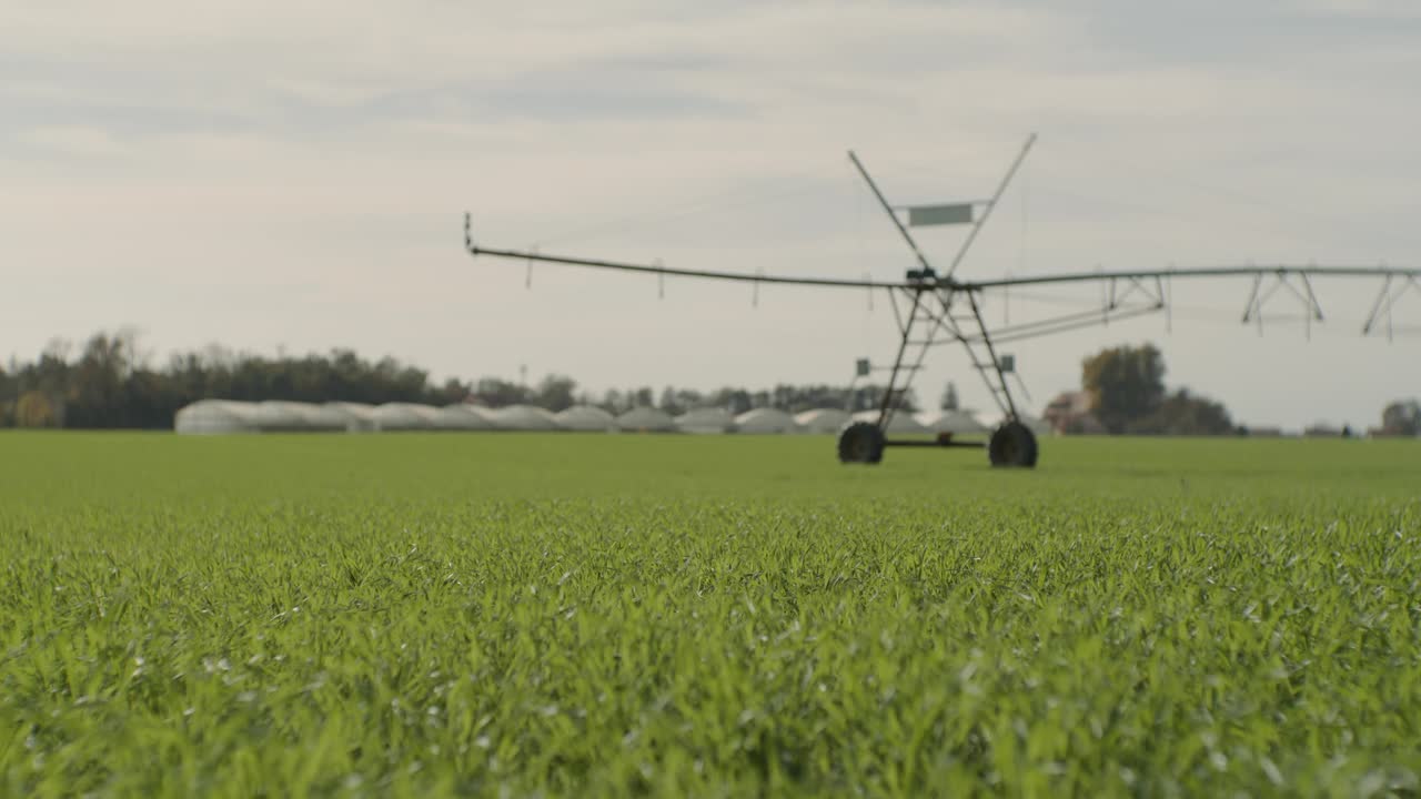 晴天阴天，绿色农业景观上的灌溉机械吊车镜头视频素材