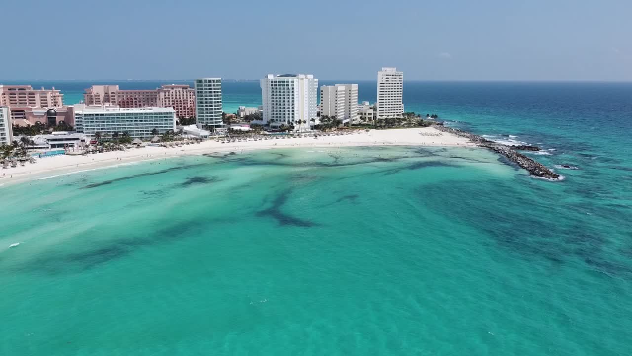 坎昆的海岸线上碧绿的海水和熙熙攘攘的海滨酒店，鸟瞰图视频素材