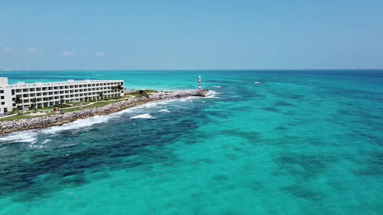 坎昆海岸线上有灯塔和酒店，晴朗的天空下湛蓝的海水，鸟瞰视频素材