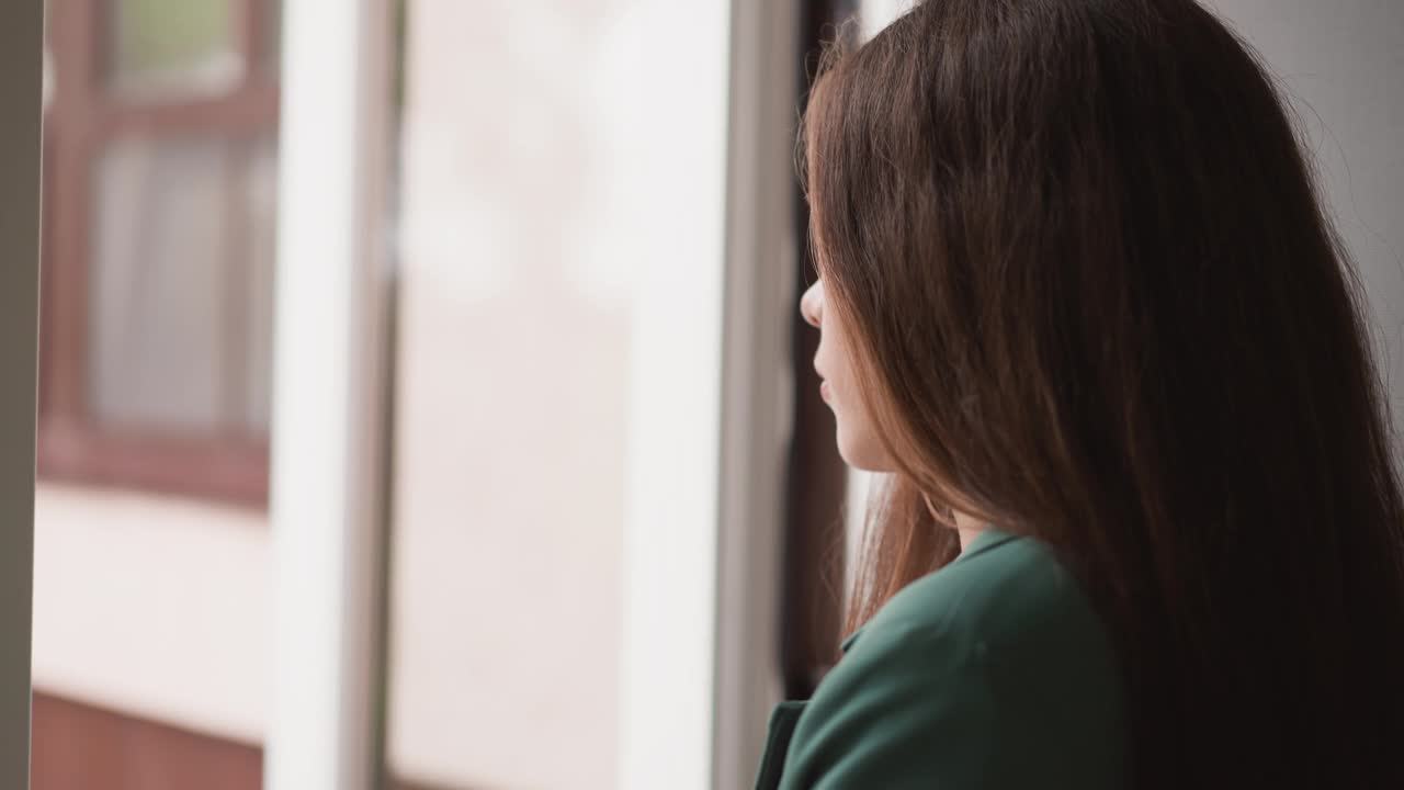 一名妇女看着屋外不断下着雨视频素材