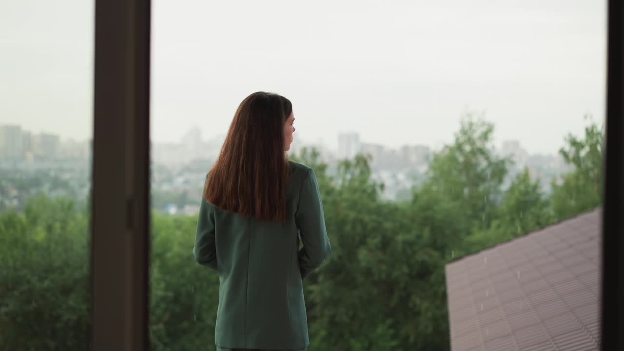 雨中站在屋顶上的愁眉苦脸的女人视频素材