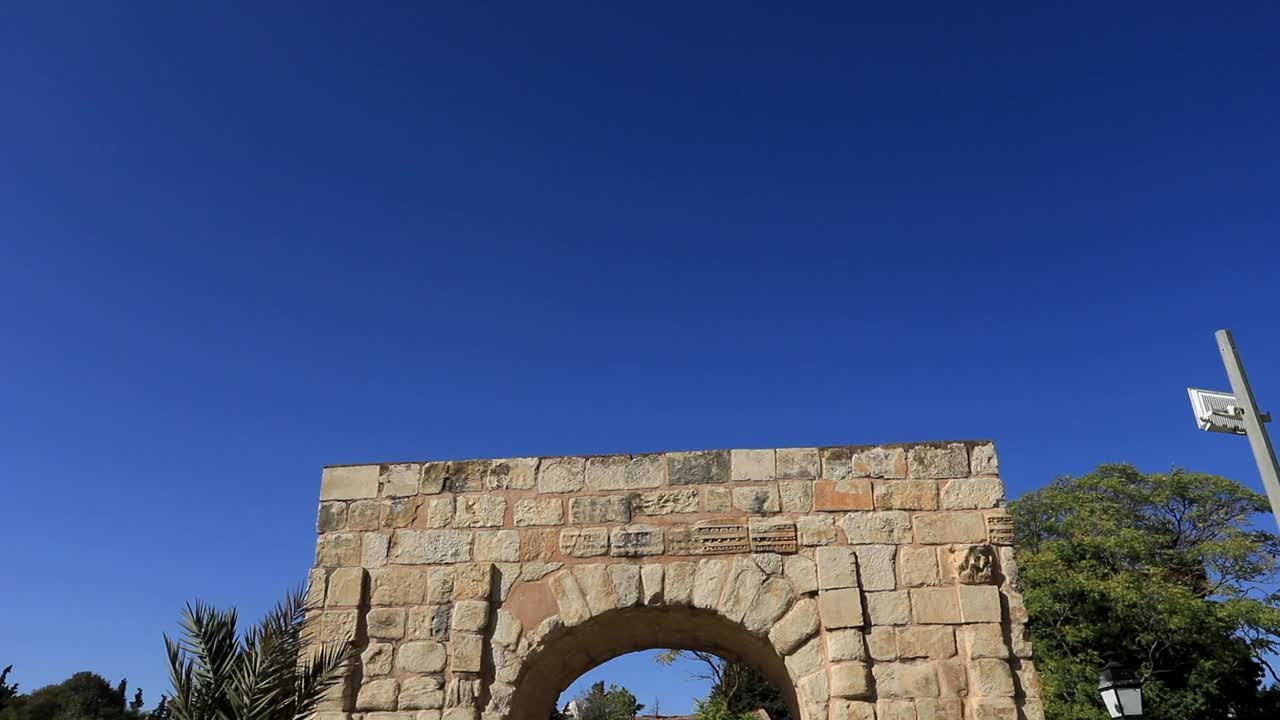 阳光明媚的日子里，古罗马拱门遗址在杜加，清澈的蓝天背景，静态拍摄视频素材