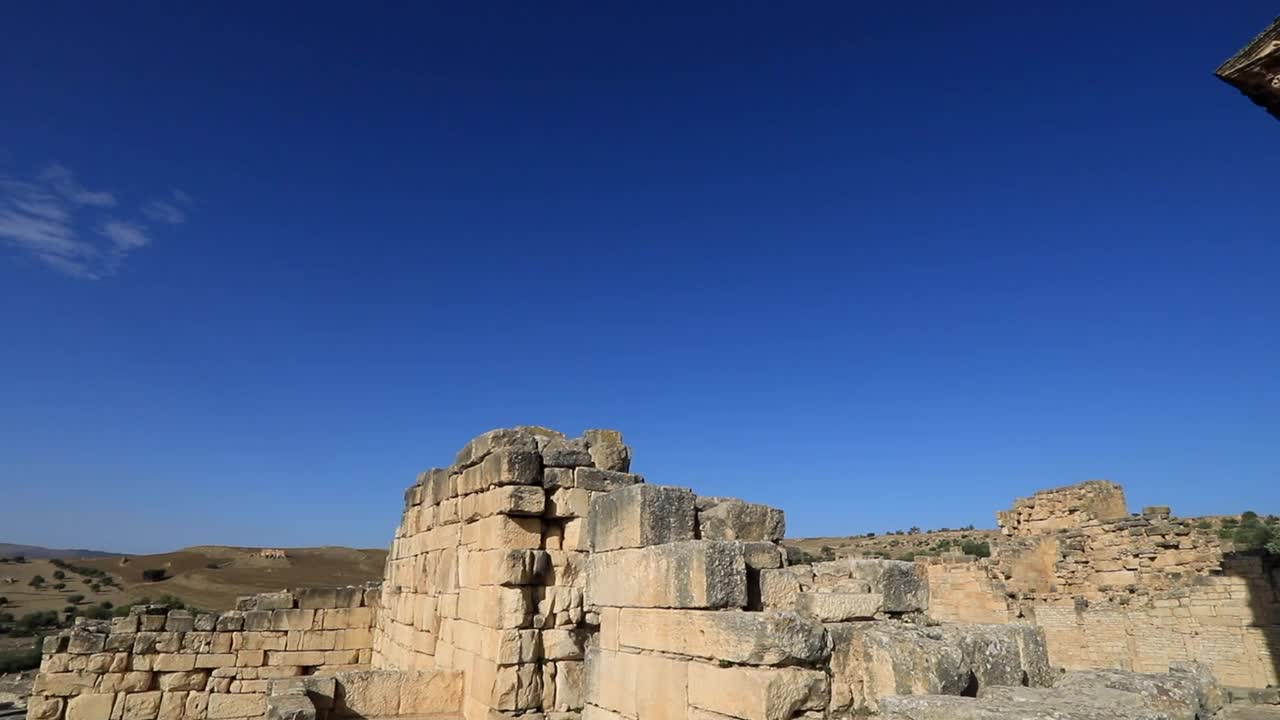 清晨的阳光洒在杜加的罗马废墟上，湛蓝的天空衬托着古老的建筑视频素材