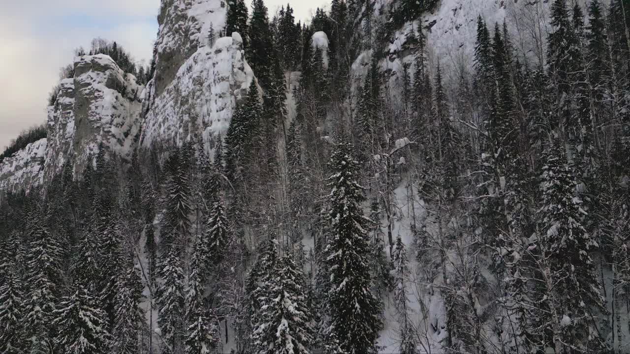 从鸟瞰的角度来看，冬天是广阔的。夹。白雪皑皑的风景，有山脉和森林，还有徒步旅行的游客。视频素材