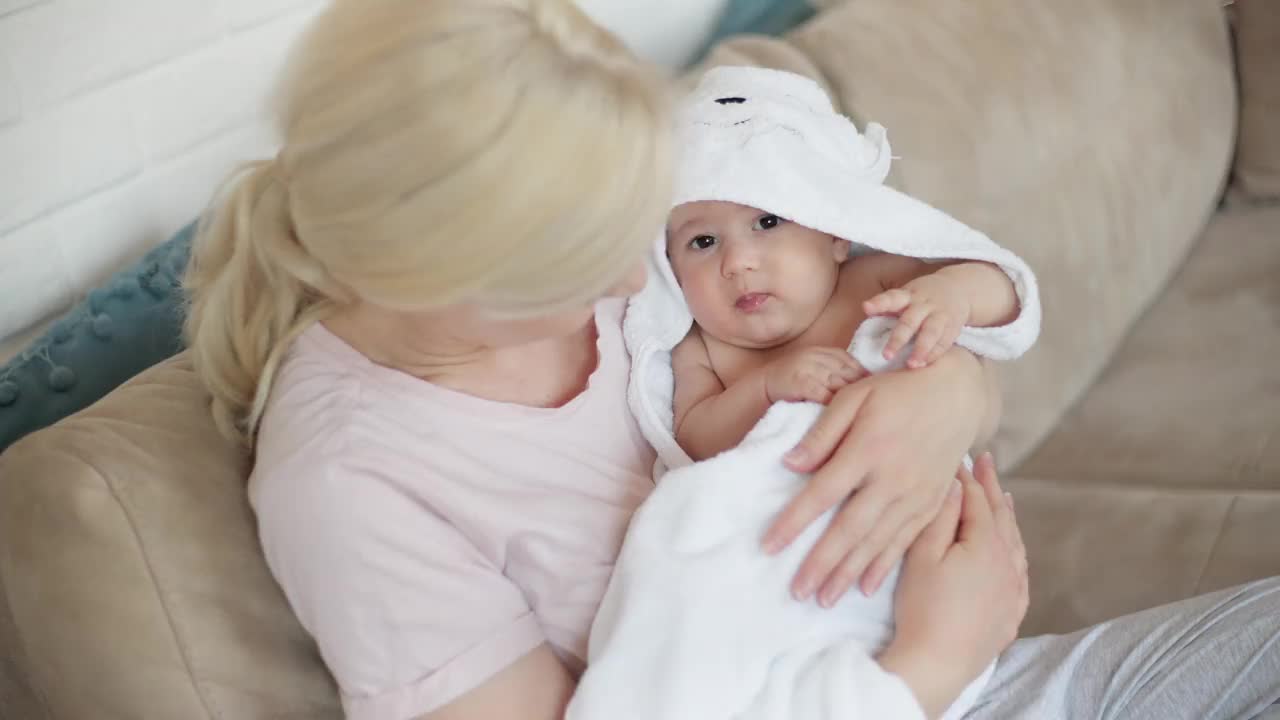 一位慈爱的母亲抱着并摇着她刚出生的男婴视频下载