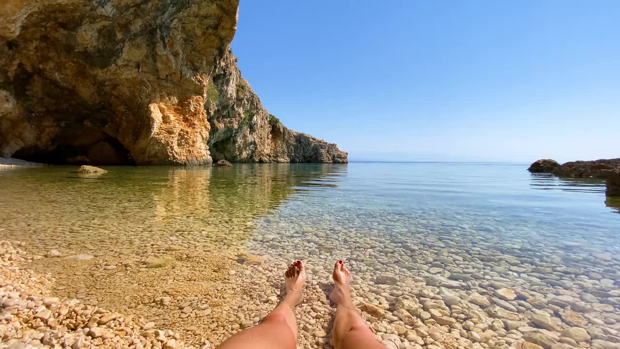 享受夏天，女人的腿浸入清澈的海水，个人的视角视频素材