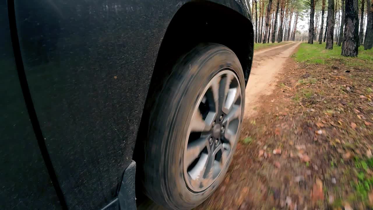 在森林深处行驶的汽车。近距离观察旋转的轮胎视频素材