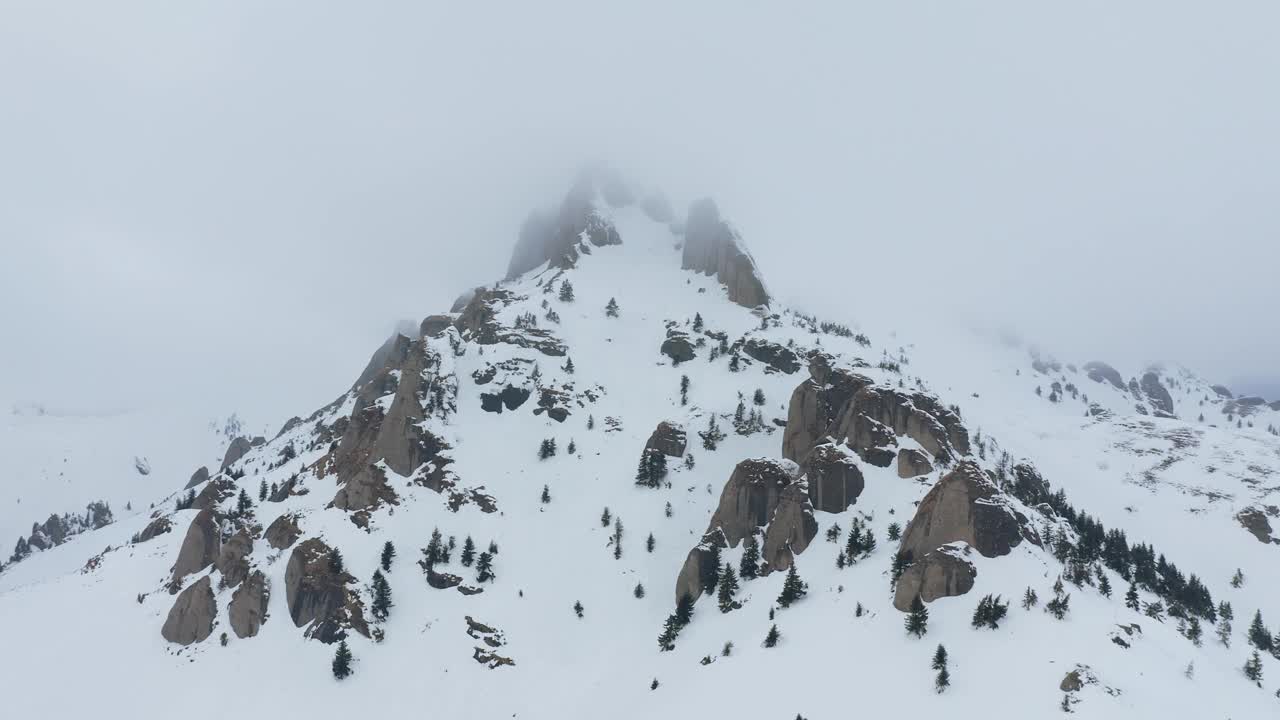 雪山山峰被云笼罩在一个宁静的，未被破坏的景观，鸟瞰视频素材