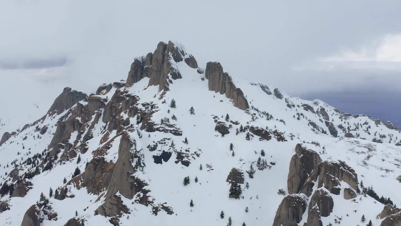 崎岖的丘卡斯山峰顶布满了积雪，阴天下，冬天的景色视频素材