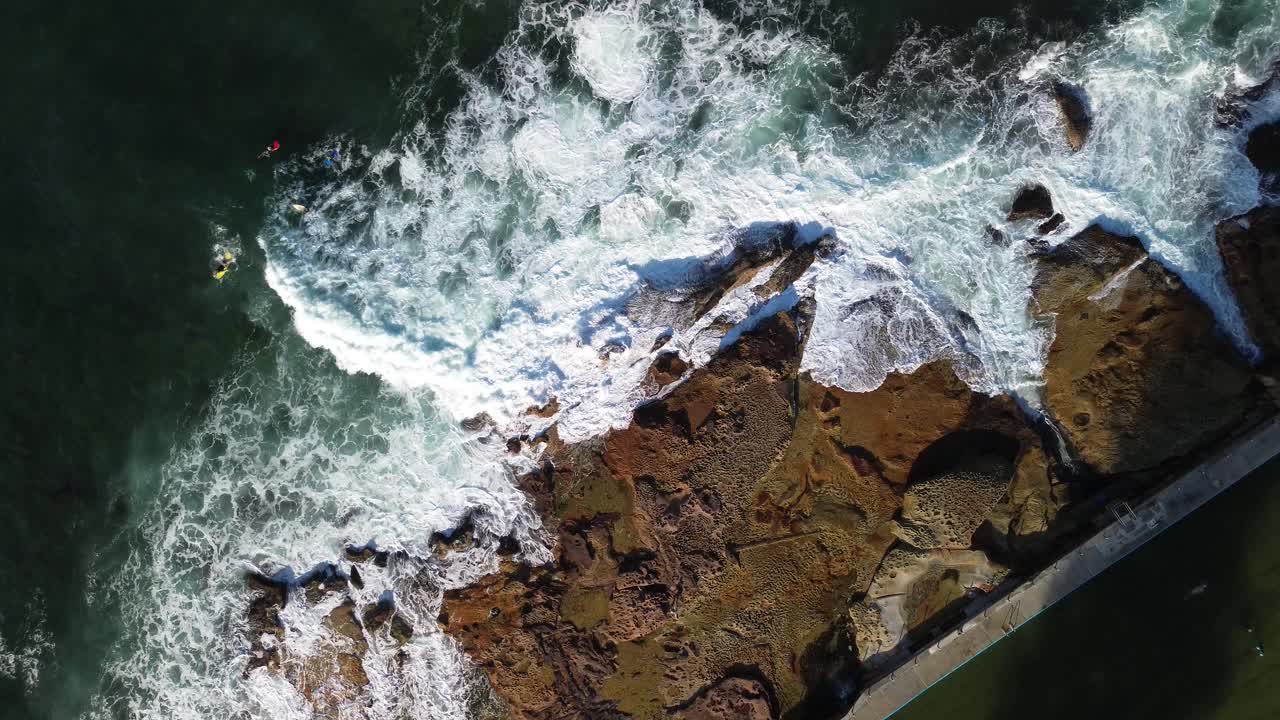 令人惊叹的海浪海景，冲浪者和岩石池在迪埃，北海滩，新南威尔士州，悉尼，澳大利亚。无人机画面4K视频素材