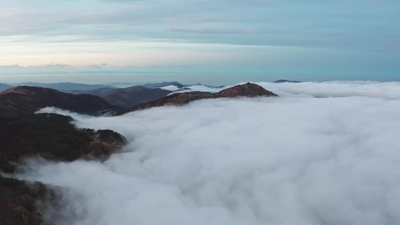 黎明的薄雾笼罩着群山，厚厚的云层在山谷中翻滚，宁静而雄伟视频素材