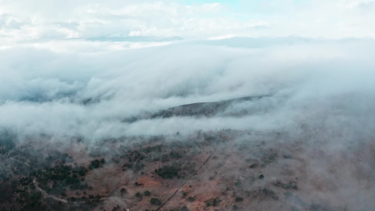 云雾翻滚在干燥的山区景观在黎明，鸟瞰图视频素材