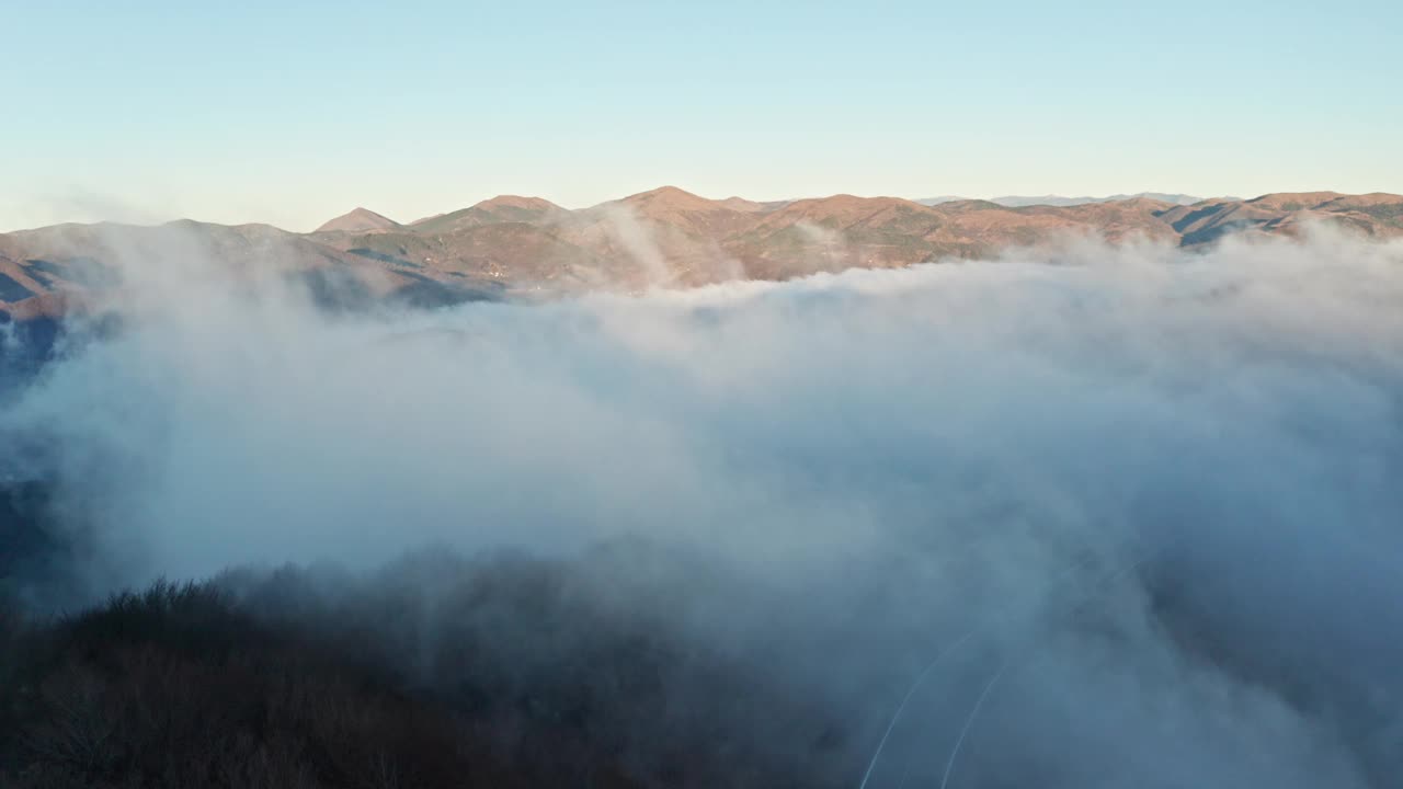 日出时，山峰穿过云层，鸟瞰图视频素材