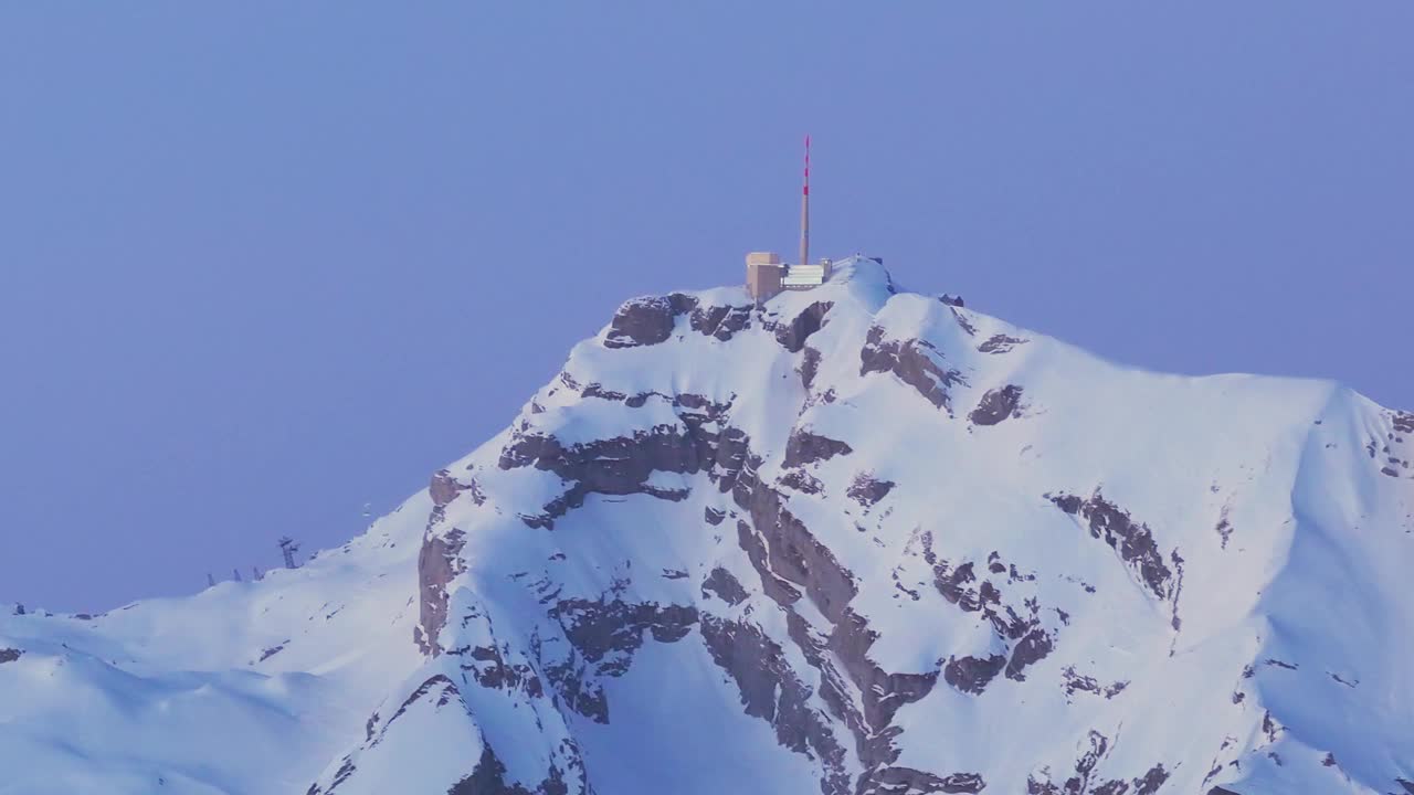 从这个迷人的无人机视角，见证日出在白雪覆盖的山脉剪影上的壮观景象。视频素材