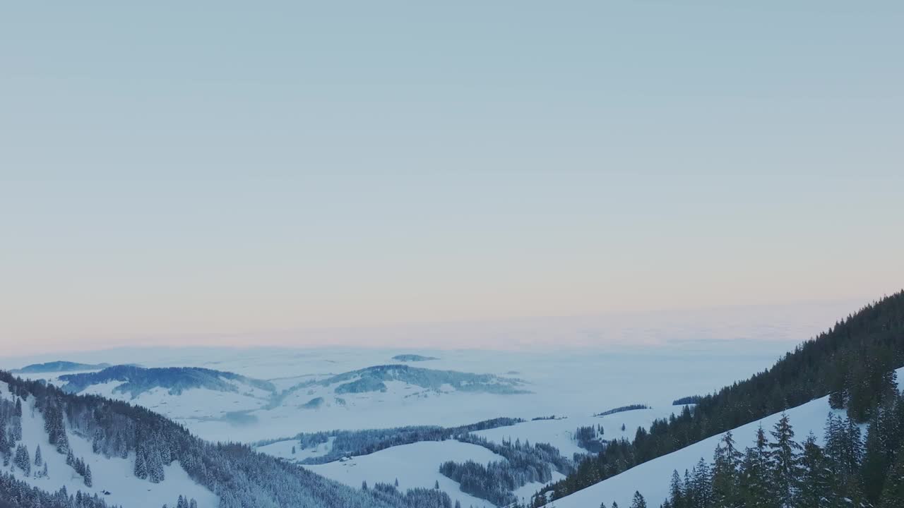 迷人的鸟瞰图展示了日出时雪山轮廓的宁静景象，由无人机拍摄。视频素材