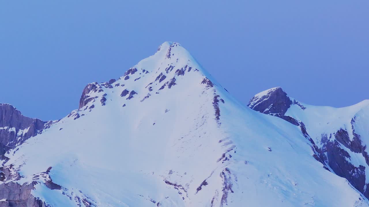 通过这个迷人的无人机镜头享受日出在雪山轮廓上的全景。视频素材