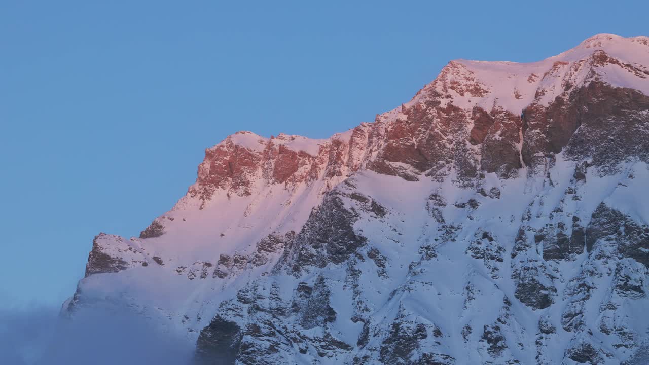 从这个迷人的无人机视角，见证日出在白雪覆盖的山脉剪影上的壮观景象。红山峰视频素材