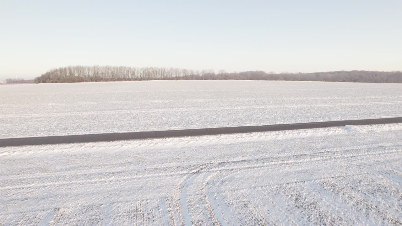 农业低地在日出时被厚厚的积雪覆盖。无人机航拍视频素材