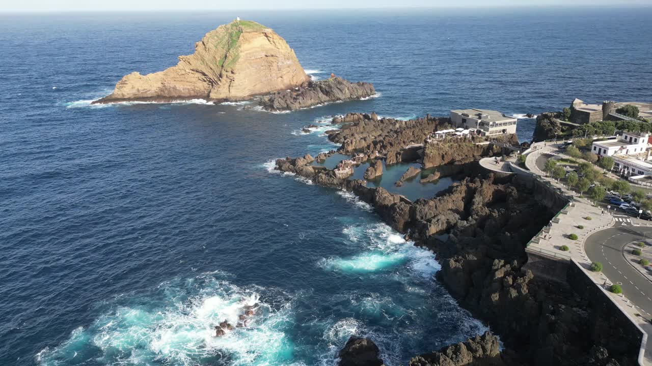 航拍葡萄牙马德拉岛的莫尼兹港镇海岸和蜗牛岩(Ilheu Mole)视频素材