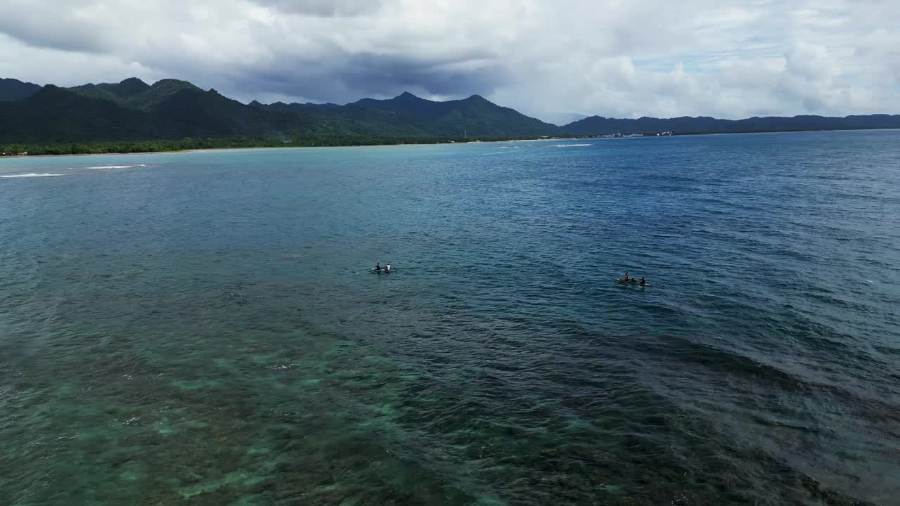 航拍冲浪者在水晶水域的阿戈霍圣安德烈斯，卡坦万内斯，菲律宾，山脉背景视频素材