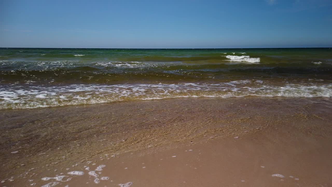 在一个晴朗的日子里，海浪轻轻地拍打着瑞典哥特兰岛的沙滩视频素材