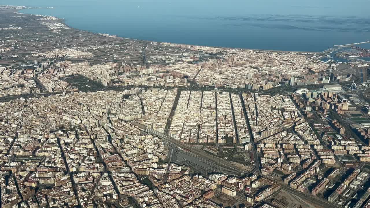 西班牙瓦伦西亚市。全景鸟瞰图，在黄金时段从机场起飞的飞机驾驶舱拍摄的飞行员视角。海港和市中心的景色。2000米高。4 k 60 fps视频素材