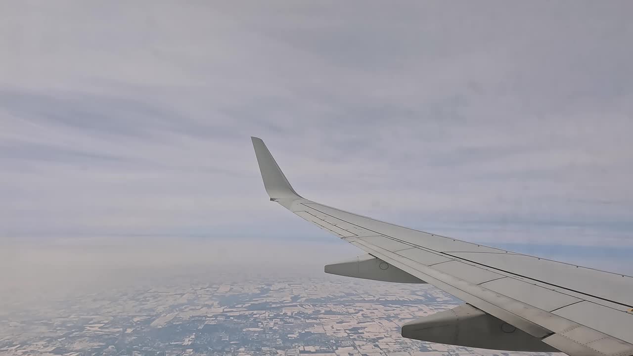 冬日透过飞机窗户鸟瞰白雪覆盖的风景视频素材