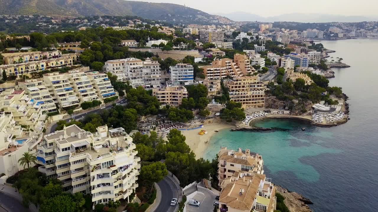 海滩伊莱塔斯与清澈的海水，海滩游客，和周围的建筑在一个阳光明媚的日子，无人机拍摄，鸟瞰图视频素材