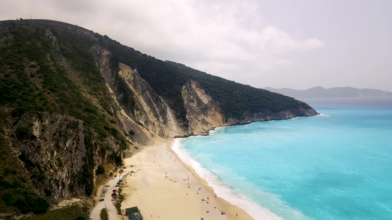 凯法利尼亚岛上的默托斯海滩，展示了绿松石般的海水和白色的沙滩，以山为背景，鸟瞰图视频素材