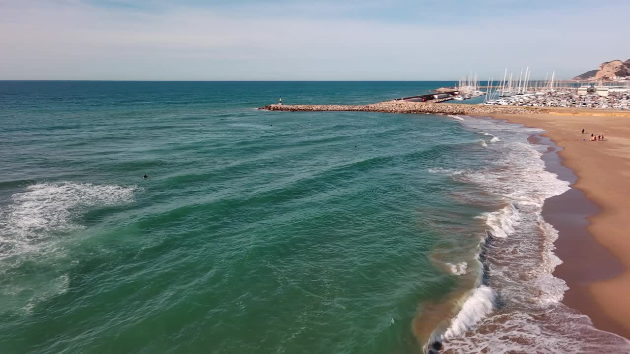 吉尼斯塔港有蔚蓝的海水和停泊的游艇，温柔的海浪拍打着沙滩，阳光明媚的日子，鸟瞰视频素材