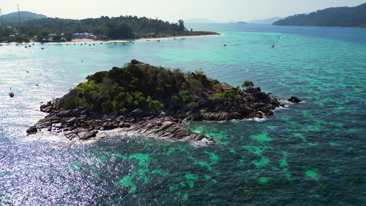 海滩岩崖岛碧蓝碧海。平稳的空中俯视飞行，飞越无人机
4 k的片段视频素材