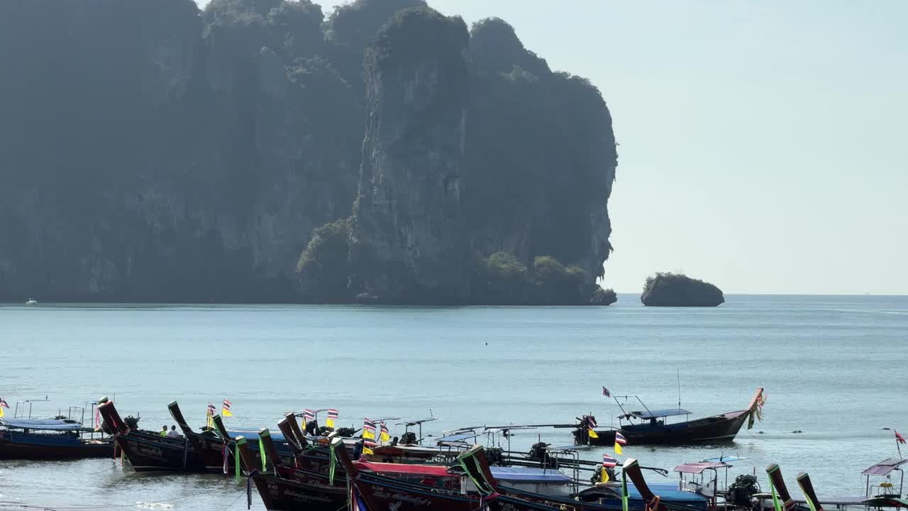 泰国长尾船停靠在陡峭的石灰岩甲米附近的海滩上视频素材