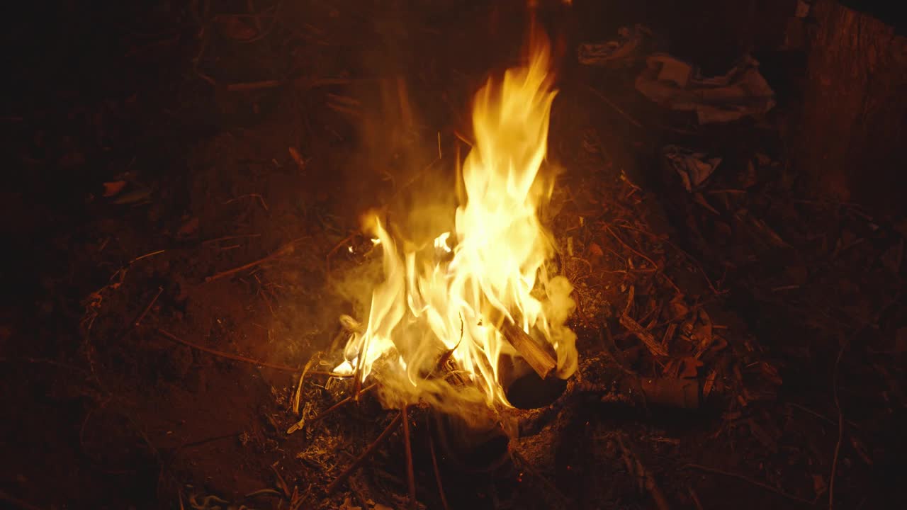 在地上燃烧木头并发出橙色火焰的篝火，野营烧烤视频素材