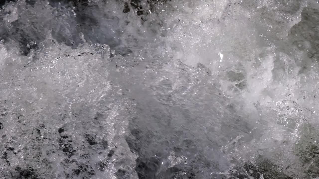 山间河流以瀑布的形式在岩石间流动视频素材