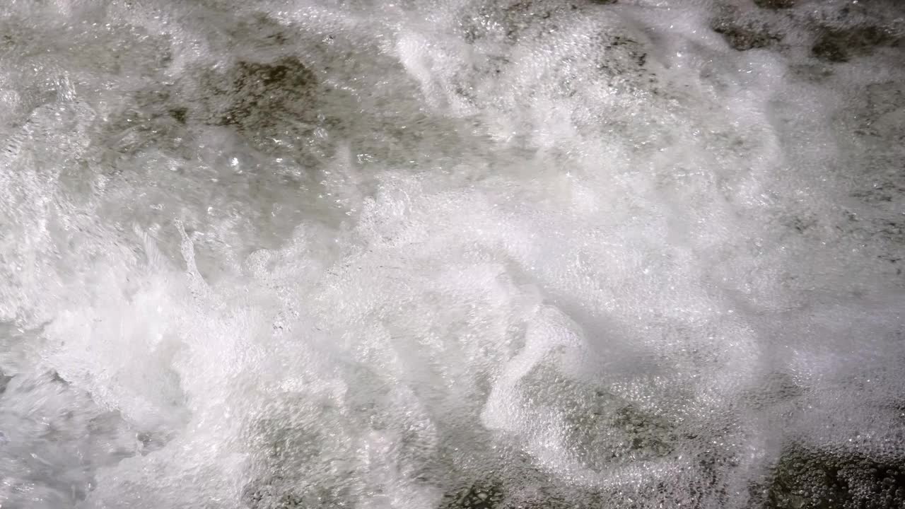 山间河流以瀑布的形式在岩石间流动视频素材