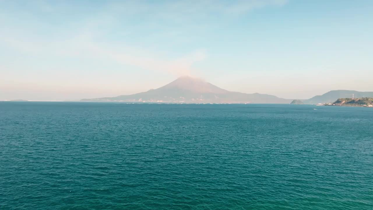 鸟瞰鹿儿岛湾的蓝色大海和洒满烟雾的樱岛火山视频素材