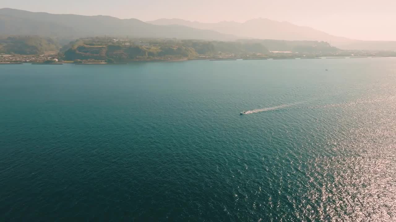 在晴朗的日子里，一艘渔船在蓝色的大海上航行视频素材