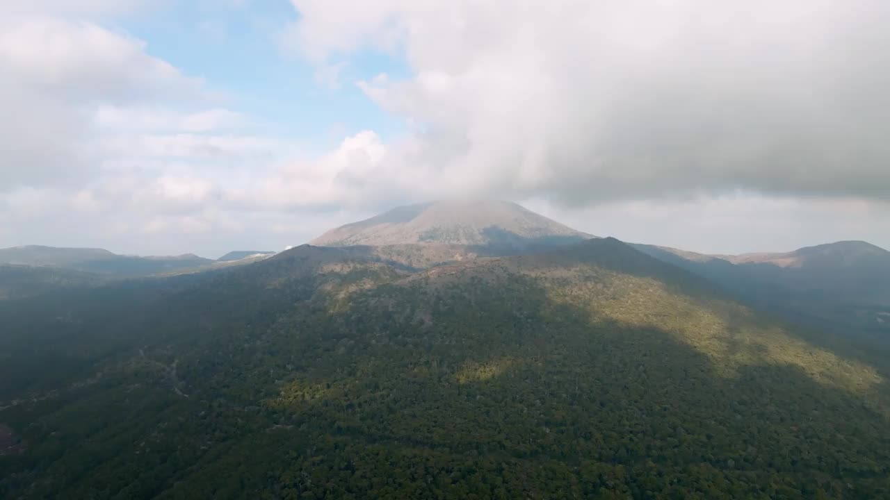 鸟瞰覆盖火山的茂密森林和雾岛-金湾国家公园的山脉，Onami池塘视频下载