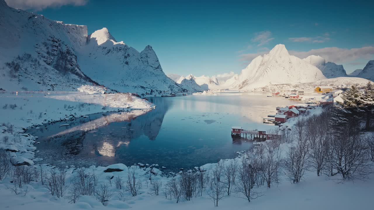 全景冬季景观，白雪皑皑的山脉和被雪覆盖的萨克里索伊村，以及挪威罗弗敦群岛的北欧建筑房屋视频素材