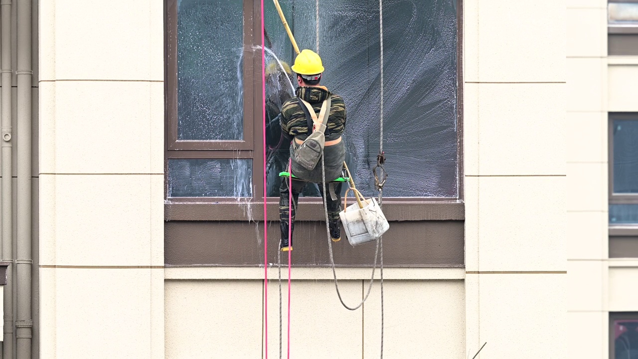 工人们在高层建筑外清洗玻璃视频下载