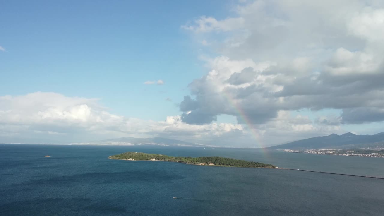 在多云的天空下，一个小岛坐落在浩瀚的海洋中视频素材