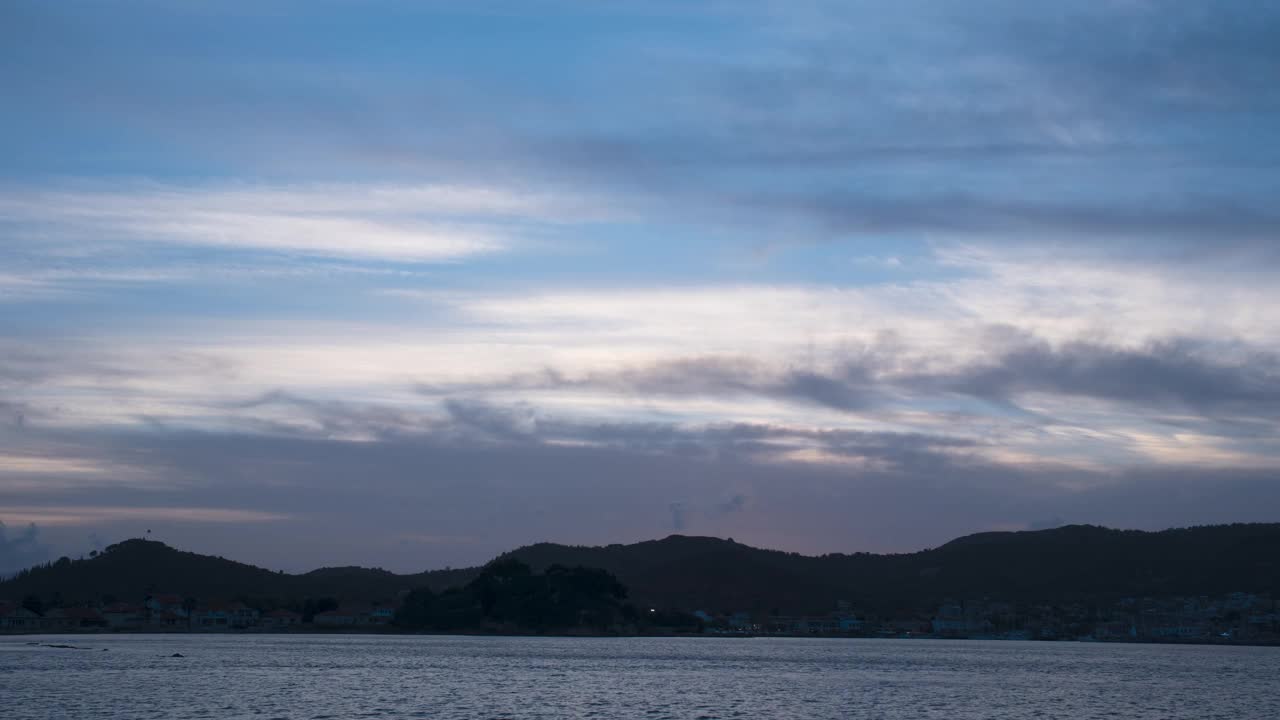 夕阳映在湖面上，山影映衬着五彩斑斓的天空视频素材